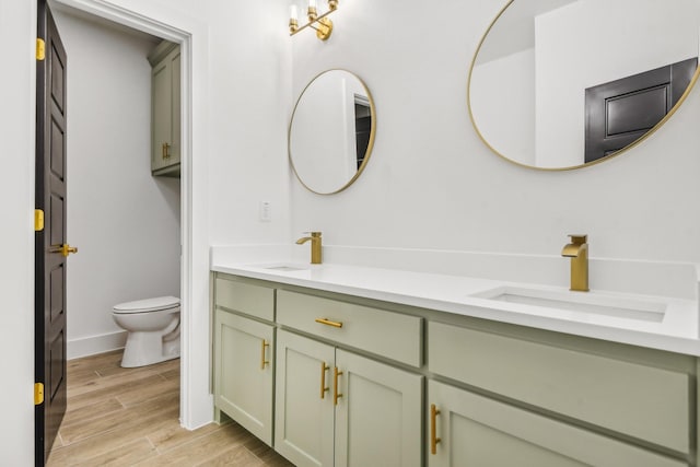 bathroom with wood-type flooring, toilet, and vanity