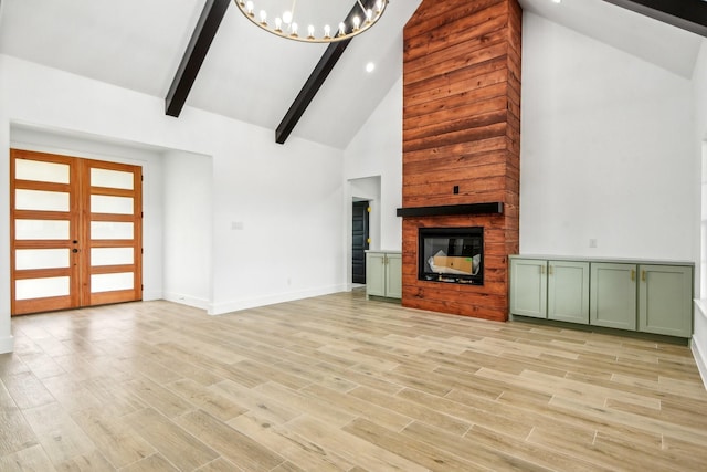 unfurnished living room featuring high vaulted ceiling, a chandelier, light hardwood / wood-style floors, french doors, and beamed ceiling