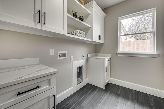 clothes washing area featuring cabinet space, hookup for a washing machine, baseboards, and electric dryer hookup