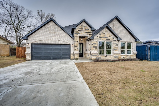 view of front of house with an attached garage, fence, concrete driveway, and brick siding