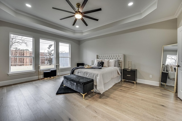 bedroom featuring a raised ceiling and light wood-style flooring