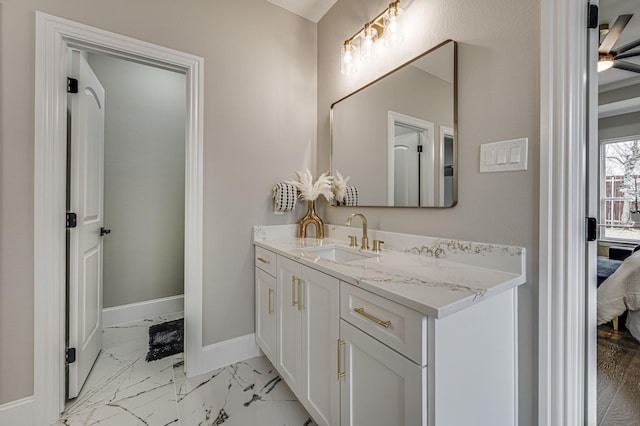 ensuite bathroom with marble finish floor, baseboards, ensuite bathroom, and vanity