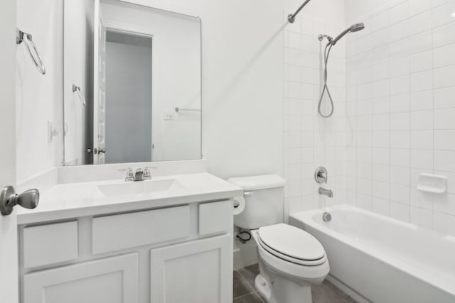 full bathroom featuring tiled shower / bath combo, vanity, and toilet