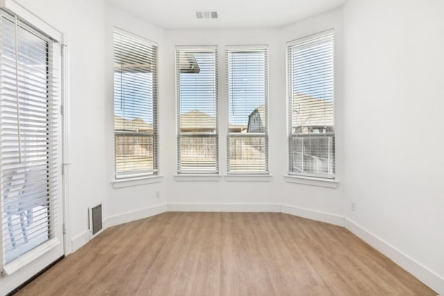 unfurnished room featuring a healthy amount of sunlight and light wood-type flooring