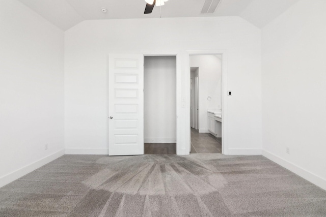 unfurnished bedroom featuring lofted ceiling, connected bathroom, and light carpet