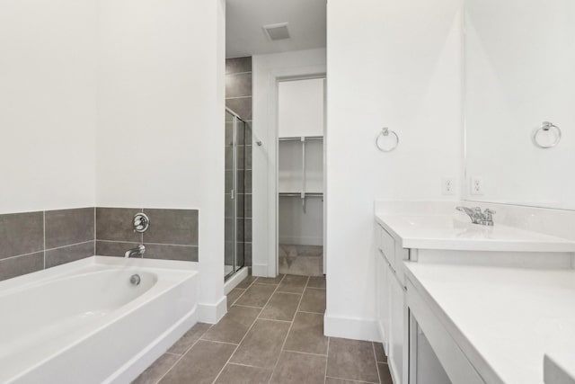 bathroom with tile patterned floors, plus walk in shower, and vanity