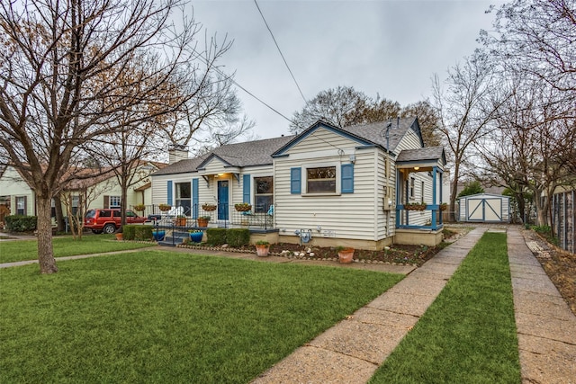 view of front of house featuring a shed, a front yard, and covered porch