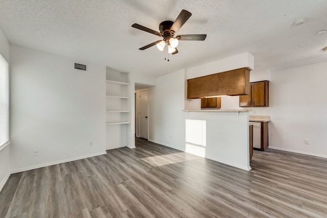 5109 Herrick Ct Unit A-D, Haltom City, TX 76117 - unfurnished living room featuring ceiling fan, wood finished floors, a textured ceiling, baseboards, and built in features