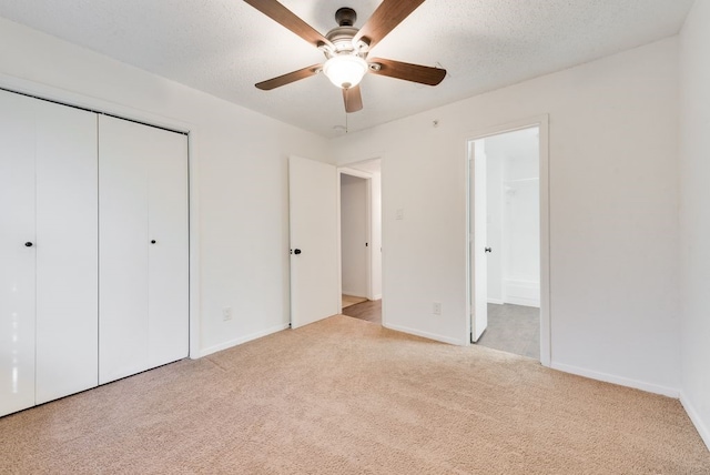 unfurnished bedroom featuring connected bathroom, light colored carpet, a closet, and a textured ceiling