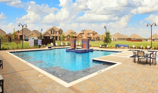 view of swimming pool featuring pool water feature and a patio area