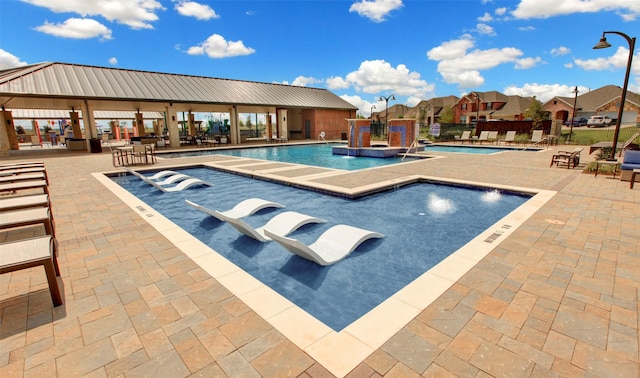 view of pool featuring pool water feature, a hot tub, and a patio area