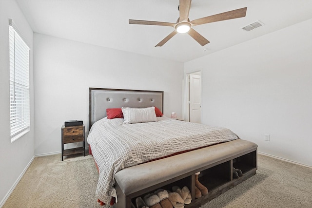 bedroom featuring multiple windows, light carpet, and ceiling fan