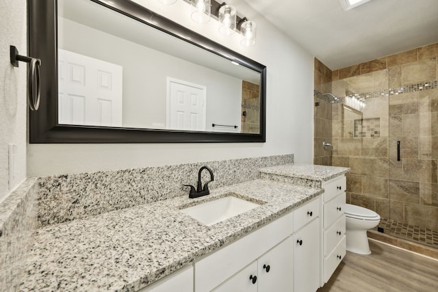 bathroom with wood-type flooring, toilet, a shower with door, and vanity