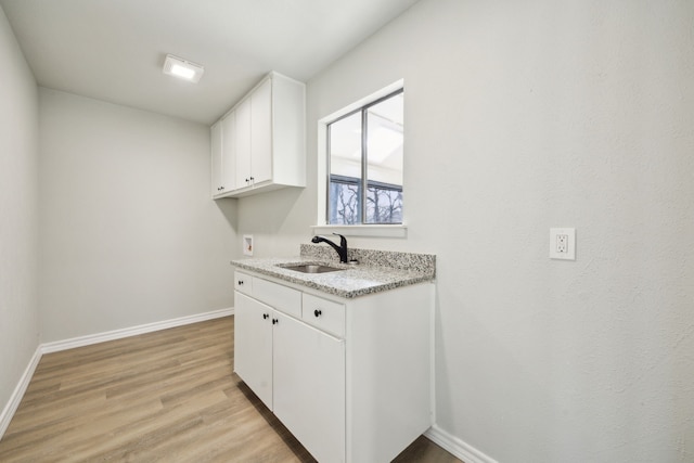 washroom featuring cabinets, washer hookup, light hardwood / wood-style floors, and sink