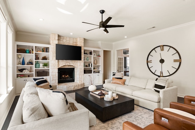 living room with crown molding, ceiling fan, and a fireplace