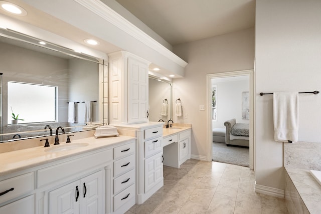 bathroom featuring vanity and tiled tub