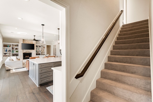 staircase with hardwood / wood-style flooring and a fireplace