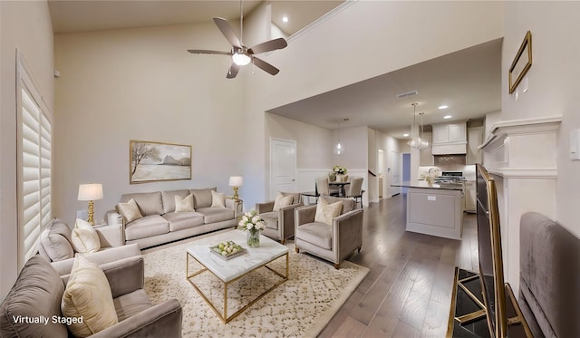 living room featuring ceiling fan, dark wood-type flooring, and a towering ceiling