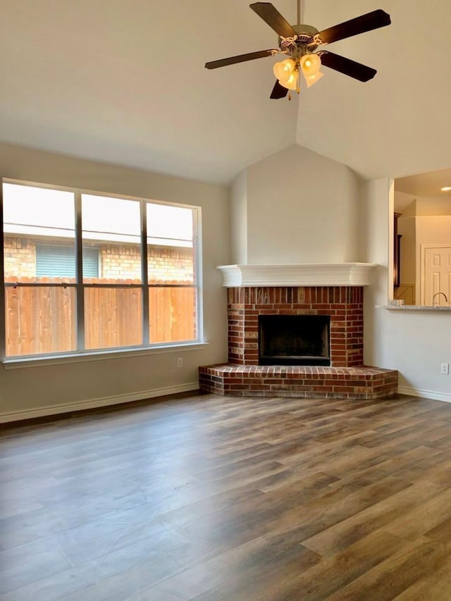 unfurnished living room featuring ceiling fan, lofted ceiling, dark wood-type flooring, and a fireplace