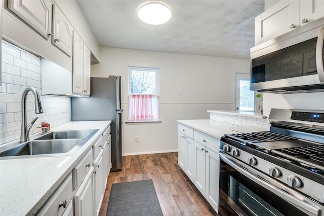 kitchen featuring white cabinetry, sink, dark wood-type flooring, and stainless steel appliances