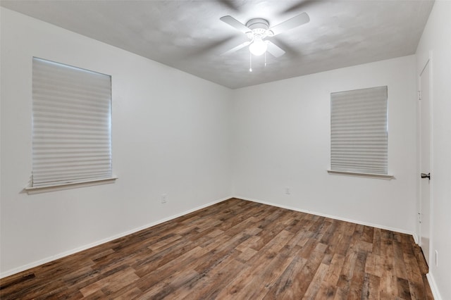 spare room featuring dark wood-type flooring and ceiling fan