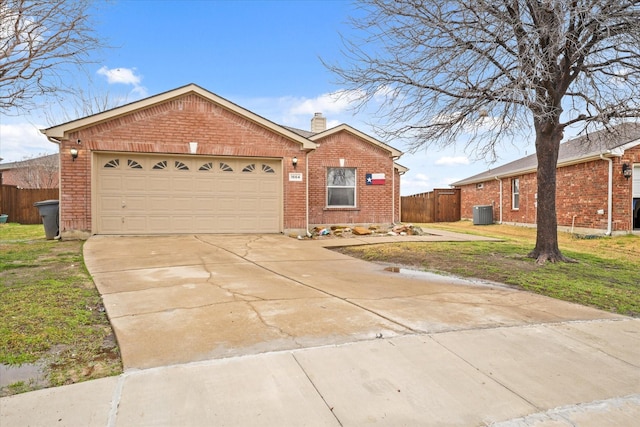 ranch-style home featuring a garage, a front yard, and central air condition unit