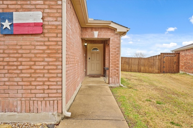 view of exterior entry featuring a yard