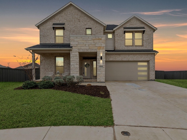 view of front of house with brick siding, a front yard, fence, a garage, and driveway