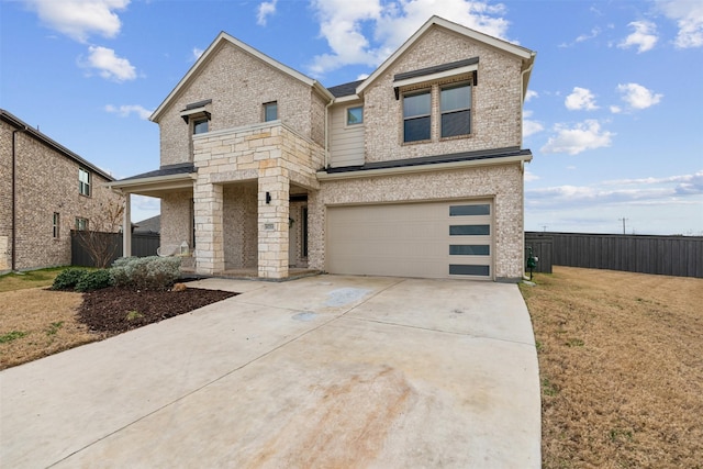 view of front of home with brick siding, fence, driveway, and an attached garage