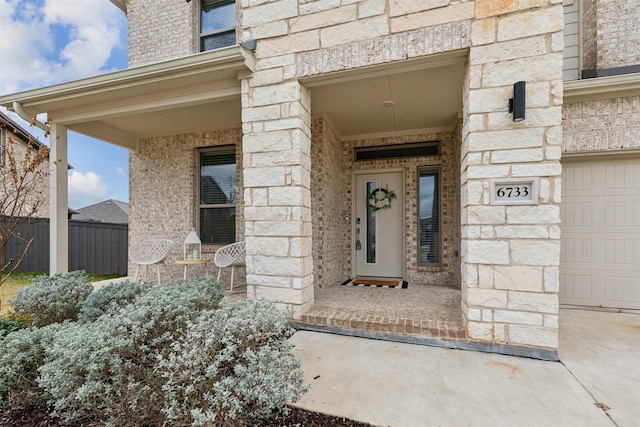 doorway to property featuring stone siding, brick siding, and fence