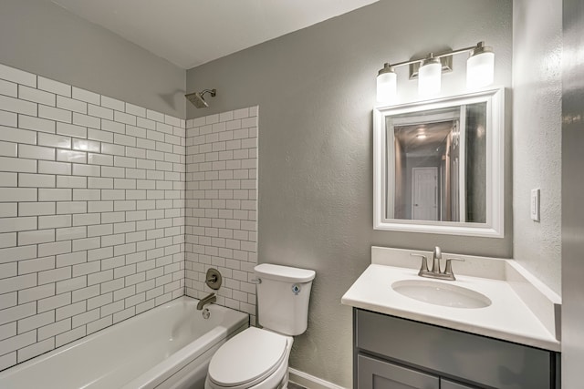 full bathroom featuring tiled shower / bath, vanity, and toilet