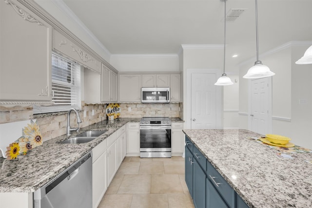 kitchen with blue cabinetry, sink, crown molding, decorative light fixtures, and stainless steel appliances