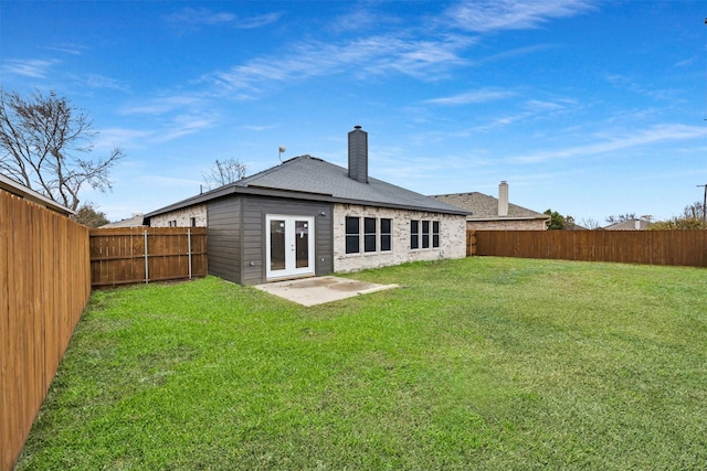 back of property with a yard, a patio area, and french doors