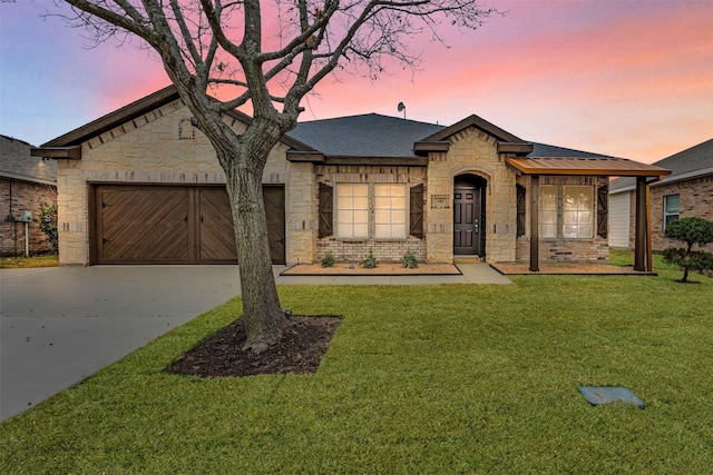 french country style house with a yard and a garage