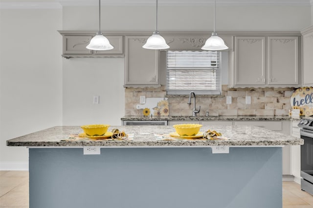 kitchen featuring hanging light fixtures, a kitchen island, sink, and gray cabinetry