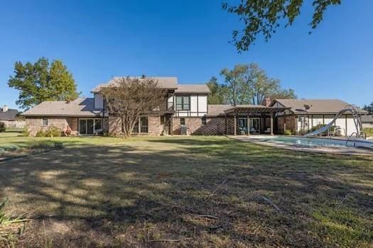 12 Brookhaven Dr, Lucas, TX 75002 - rear view of house featuring a yard and an outdoor pool