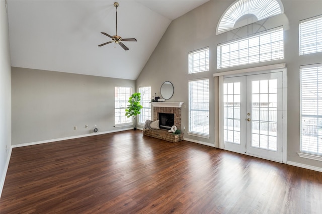 unfurnished living room with ceiling fan, a fireplace, dark hardwood / wood-style flooring, and french doors