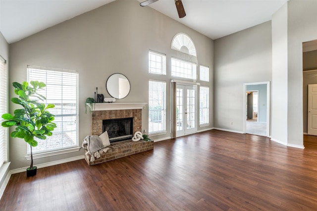 unfurnished living room featuring dark hardwood / wood-style flooring, a brick fireplace, high vaulted ceiling, and ceiling fan