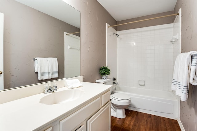 full bathroom featuring tiled shower / bath, wood-type flooring, toilet, and vanity