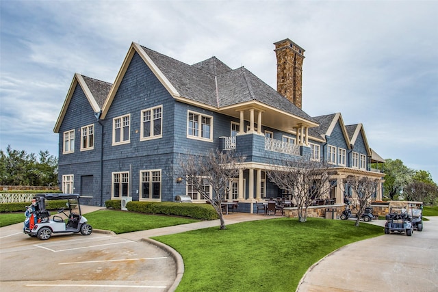 view of front facade with a balcony and a front lawn