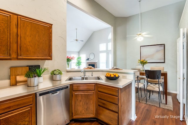 kitchen with lofted ceiling, sink, dark hardwood / wood-style flooring, stainless steel dishwasher, and kitchen peninsula