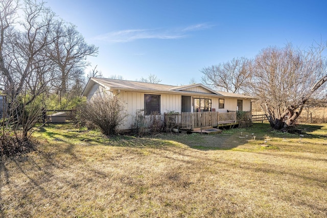 view of front of property featuring a wooden deck and a front lawn