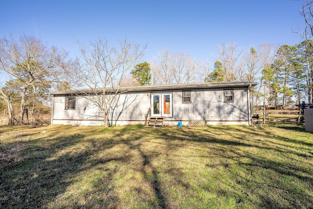 rear view of property with a lawn