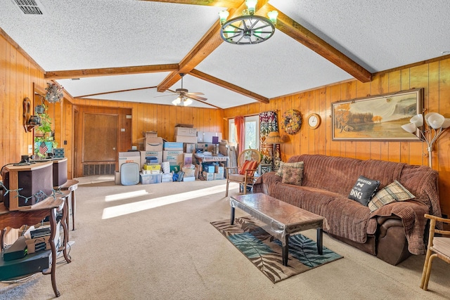 carpeted living room featuring ceiling fan, lofted ceiling with beams, a textured ceiling, and wood walls