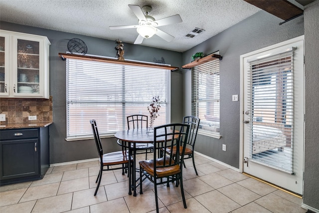 tiled dining area featuring a textured ceiling and ceiling fan