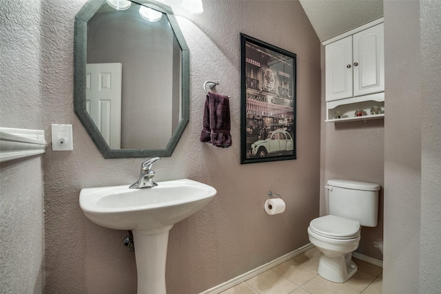 bathroom featuring lofted ceiling, toilet, and tile patterned flooring