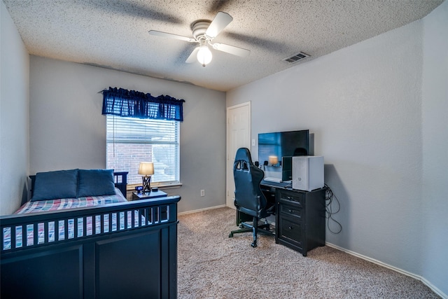 carpeted bedroom with ceiling fan and a textured ceiling