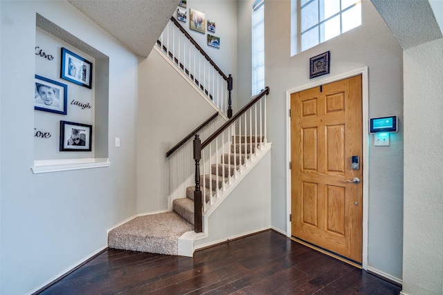 entrance foyer featuring hardwood / wood-style flooring and a towering ceiling