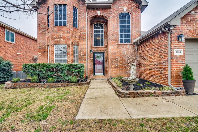 doorway to property featuring a garage and central AC unit