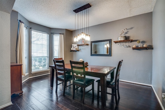 dining space featuring dark wood-type flooring and a textured ceiling